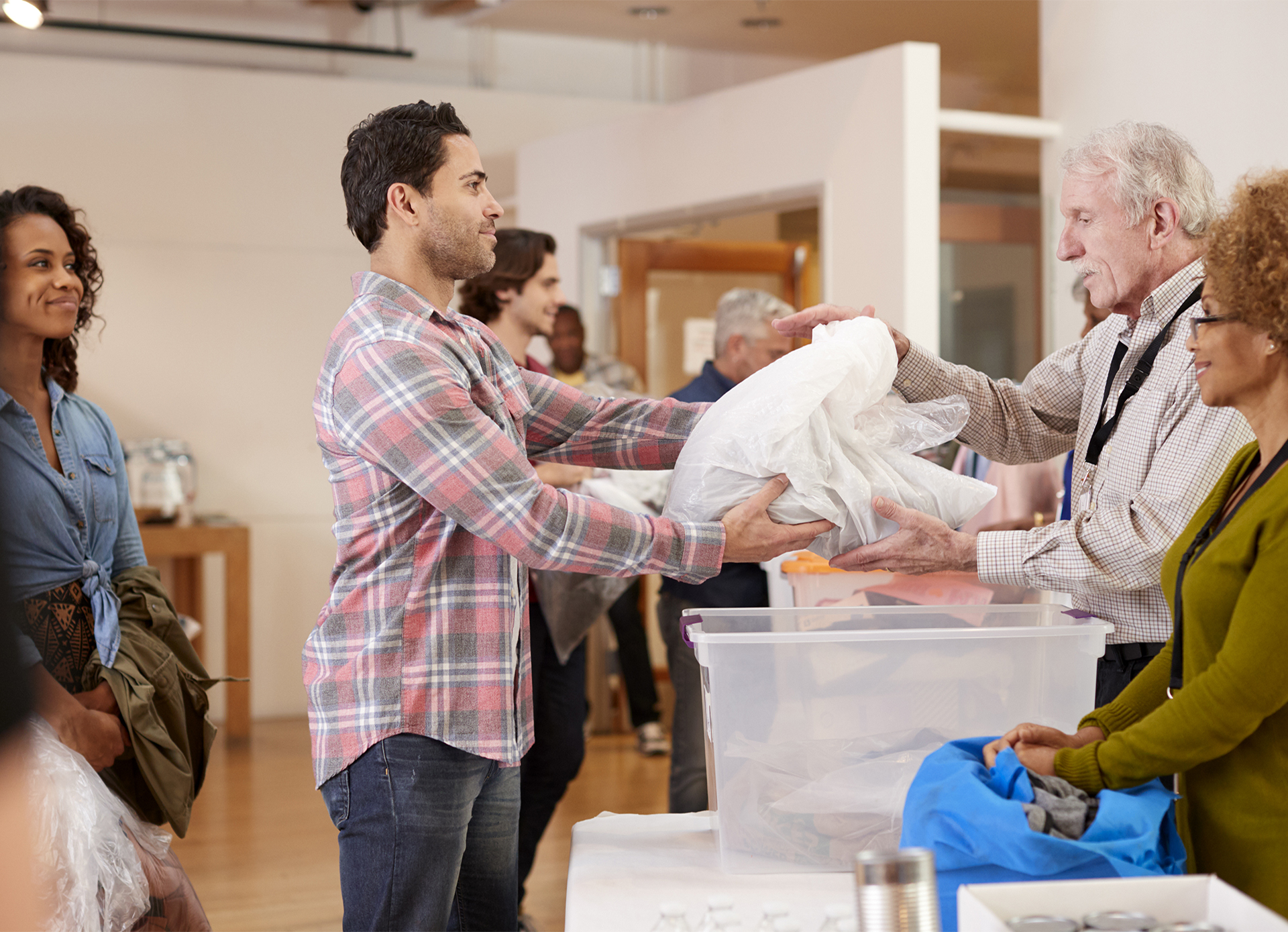 A photo of volunteers at a homeless shelter handing out supplies